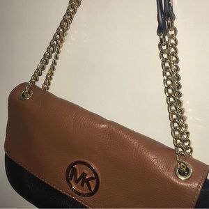 Gold strap and lettering. Black and brown leather MK purse.